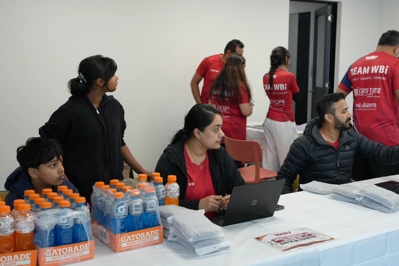 WBi volunteers ready at the tournament registration desk with laptops