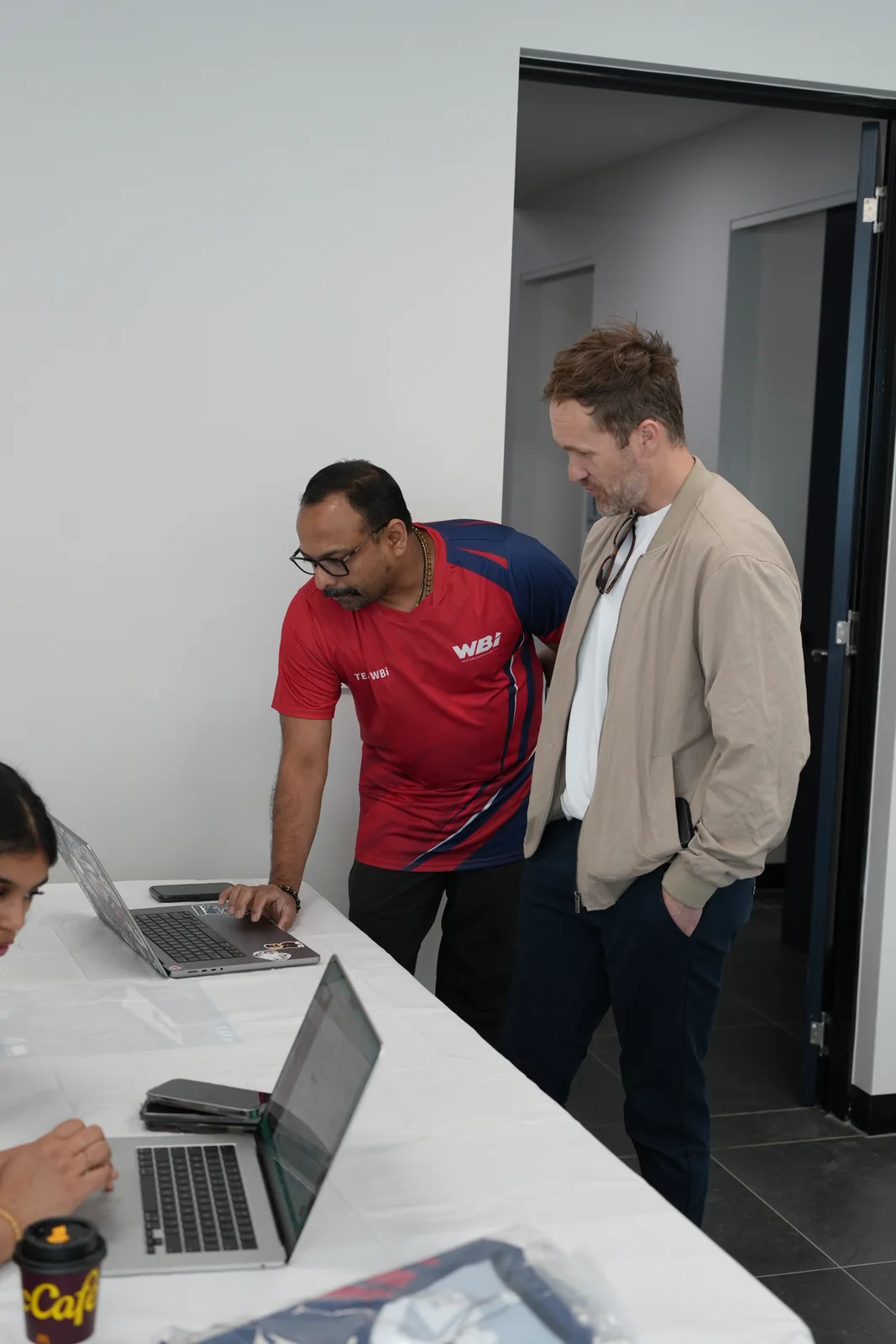 WBi President Arun K. P. Gopal and chief guest Clint Proctor beside a laptop at the tournament desk